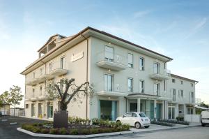 ein weißes Auto, das vor einem Gebäude geparkt ist in der Unterkunft Hotel Palmensis in Marina Palmense