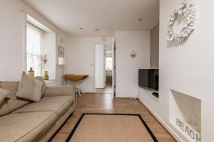 a living room with a couch and a tv at Bangor Cottage - Elie in Elie