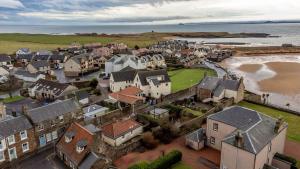 an aerial view of a town next to the ocean at Bangor Cottage - Elie in Elie