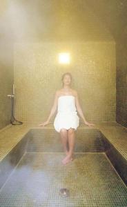 a woman in a bath tub in a bathroom at Spa & Relax in Cairo Montenotte