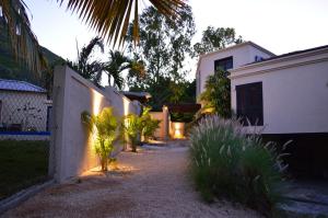 einen Weg, der zu einem Haus mit einem Zaun führt in der Unterkunft Le Gite du Bonheur Guest House & Car Rental in Tamarin