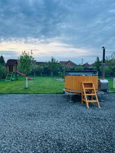 ein Spielplatz mit einer Holzbank und einem Tisch in der Unterkunft Tiny House Doi Frați in Drăguş