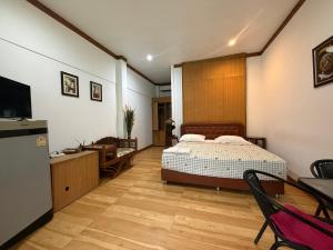 a bedroom with a bed and a desk and a television at SouanSonBeachResort in Klaeng