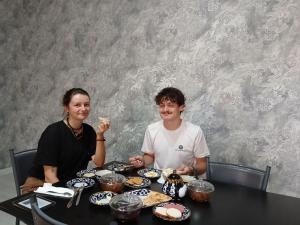 a man and a woman sitting at a table with food at Guest House Bekturdi in Khiva
