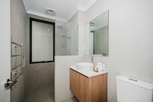 a white bathroom with a sink and a mirror at Hello Dolphins Villas in Mandurah +11 photos