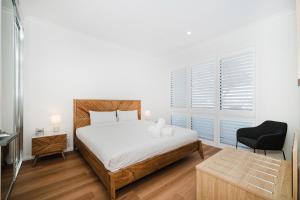 a bedroom with a bed and a desk and a chair at Hello Dolphins Villas in Mandurah