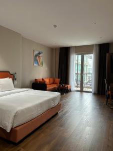 a hotel room with a bed and a couch at Sono Sallute Luxury Hotel in Ho Chi Minh City