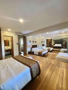 a large hotel room with two beds and a bathroom at Commander Suites de Velada in Antipolo