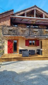 a house with a red door on a wooden deck at Le montagnard in Lullin