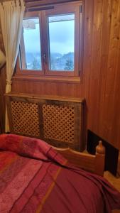 a bedroom with a bed and a window at Le montagnard in Lullin