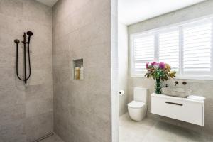 a bathroom with a toilet and a sink and a window at Toi Toi Apartment in Martinborough +17 photos