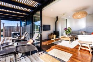 a living room with chairs and a couch and a table at Toi Toi Apartment in Martinborough