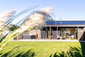 a house with a patio and a yard with grass at Toi Toi Apartment in Martinborough