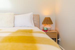 a bedroom with a bed and a lamp on a night stand at Toi Toi Apartment in Martinborough