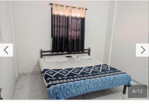 a bedroom with a bed with a blue and white blanket at Hotel Sur Sangam in Nashik +16 photos