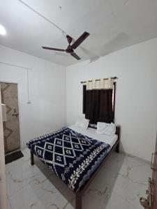 a bedroom with a bed with a ceiling fan at Hotel Sur Sangam in Nashik