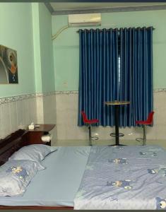 a bedroom with a bed and a table and two chairs at Hotels Motel Nhà nghỉ CHINH HOA PLASS in Ấp Ray
