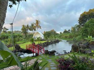 a river with a red bridge in a park at Hotels Motel Nhà nghỉ CHINH HOA PLASS in Ấp Ray
