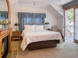 a bedroom with a large bed and a fireplace at Pacific Grove Inn in Pacific Grove