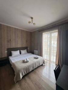 a bedroom with a bed with two towels on it at Hotel Shina in Kazbegi