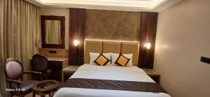 a hotel room with a bed and a mirror at Florys Residency in Ooty