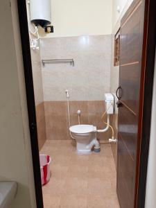 a small bathroom with a toilet in a room at Balaas Inn in Karaikal