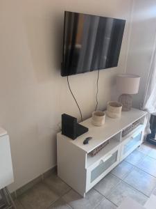 a white cabinet with a television on a wall at Sanary Soleil et Douceur V in Sanary-sur-Mer