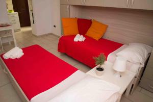 ナポリにあるCarol Houseのベッドルーム1室(ベッド2台、赤と白のシーツ付)