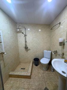 a bathroom with a toilet and a sink at Hotel Shina in Kazbegi