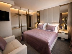 ein Hotelzimmer mit einem großen Bett und einer Couch in der Unterkunft Spa Hotel Ezeretz Blagoevgrad in Blagoewgrad