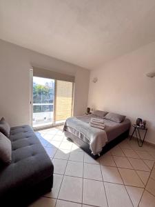 a bedroom with a bed and a couch and a window at Vacation Villa Marina in Puerto Vallarta +6 photos