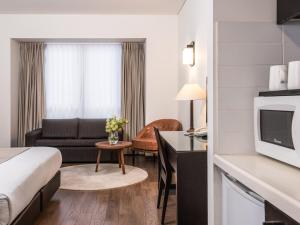 a hotel room with a bed and a couch at Vital - Urban boutique hotel TLV in Tel Aviv