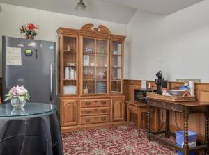 a kitchen with a refrigerator and a wooden cabinet at Pacific Grove Inn in Pacific Grove