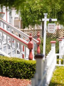 a white fence with a red fire hydrant and a sign at Pacific Grove Inn in Pacific Grove