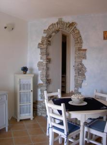 een eetkamer met een tafel en een bakstenen muur bij Villino Belvedere in Budoni
