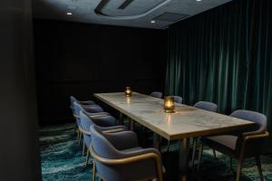 a row of tables and chairs in a room with green curtains at Bayside Geelong Hotel & Apartments, an Ascend Collection Hotel in Geelong +70 photos