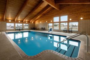 a large indoor pool with blue water in a building at AmericInn by Wyndham Lincoln South in Lincoln