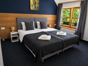a bedroom with a large bed with two towels on it at Dom Oliwski in Gdańsk
