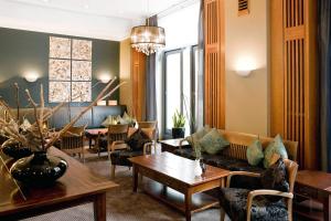 a living room with a couch and a table at Vienna House by Wyndham Sonne Rostock in Rostock