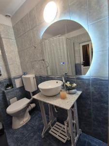a bathroom with a sink and a toilet and a mirror at Ava Studio in Cisnădie +27 photos