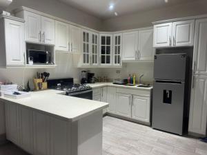 a kitchen with white cabinets and a black refrigerator at Casa KM222 in Esquipulas