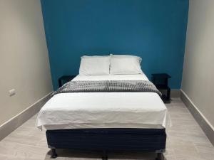 a bed in a room with a blue wall at Casa KM222 in Esquipulas +1 photo