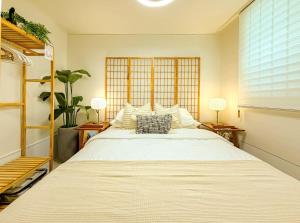 a bedroom with a large white bed with two lamps at Hongdae 10 min Family 2BR Direct Airport Bus from ICN airport in Seoul