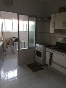 a kitchen with a stove and a counter top at Apartamento Astúrias 2 Dorms Ar Cond in Guarujá