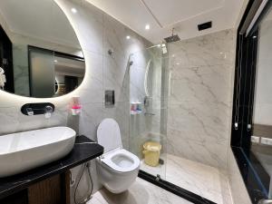a bathroom with a toilet and a sink and a shower at Hotel Hari Piorko - New Delhi Railway Station in New Delhi