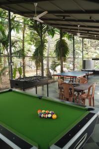 a pool table in a room with tables and chairs at Oceanature Alibaug in Alibaug