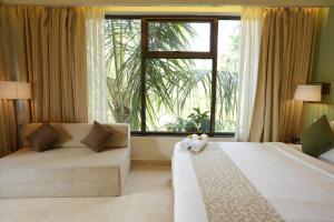 a bedroom with two beds and a large window at Oceanature Alibaug in Alibaug +126 photos