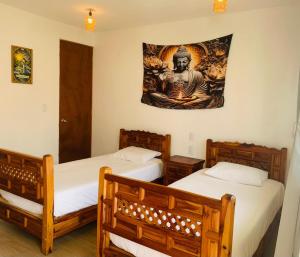 a room with two beds and a painting on the wall at Casa AmaNacer Malinalco in La Ladrillera