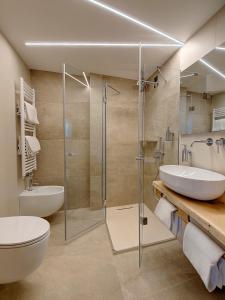 a bathroom with a toilet and a sink and a shower at Hotel Garni La Vigna - Adult Friendly in San Michele allʼAdige +36 photos