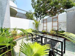 a patio with tables and chairs and plants at ECHO VILLA PHAN THiET in Phan Thiet